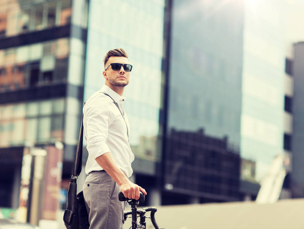 young man with bicycle on city street - Фото, зображення