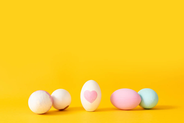 Composizione minima delle uova di arredamento su sfondo giallo
 - Foto, immagini