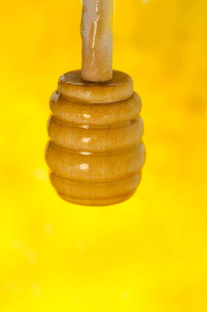 Miel en cuchara de miel de madera
 - Foto, Imagen