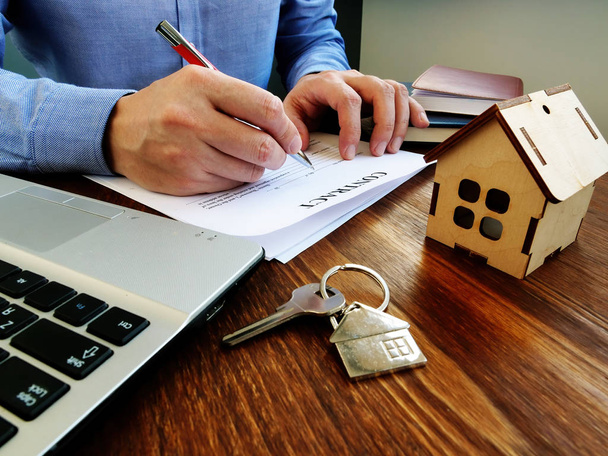 Mann unterschreibt Vertrag über Hypothek oder Immobilienkauf. - Foto, Bild
