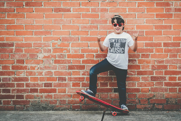 enfant avec skateboard et lunettes de soleil
  - Photo, image