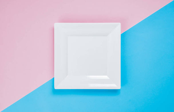 Plato blanco sobre fondo rosa y azul
 - Foto, imagen