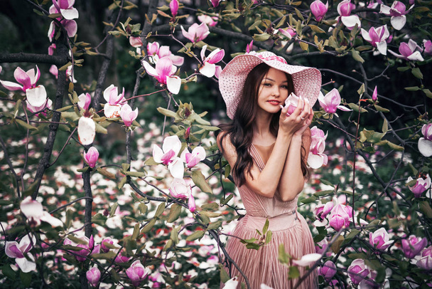 girl holding magnolia flower in her hands - Foto, Imagen