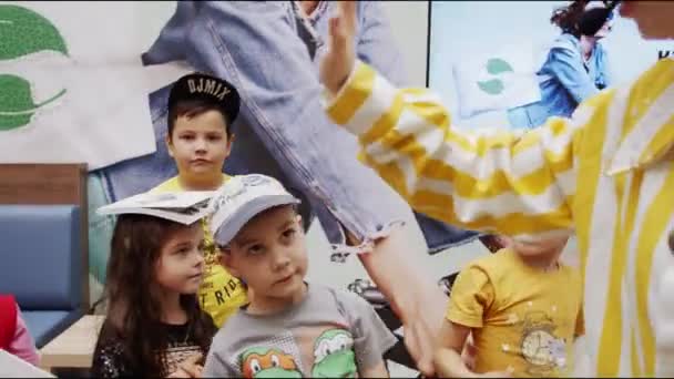 little children give five to animator at playtime in hall - Filmagem, Vídeo