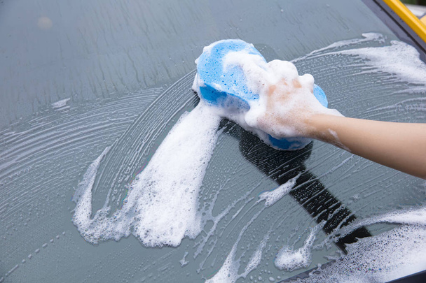 cleaning windscreen of a car with blue sponge foam. - Zdjęcie, obraz