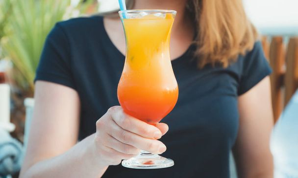 Woman hand is holding fruit cocktail. - Foto, Imagen
