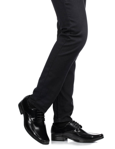 Man's feet in black trousers and black shoes isolated on white b - Photo, Image