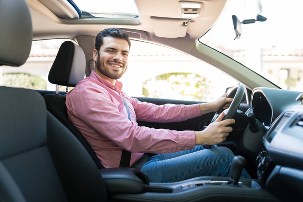 Magabiztos latin középkorú férfi mosolyog vezetés közben új autó - Fotó, kép