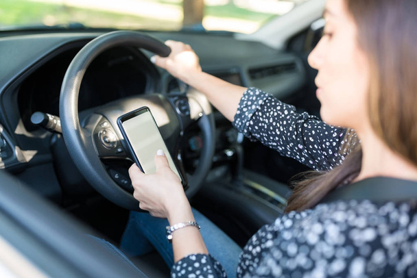 Autofahrerin benutzt Handy während sie auf Fahrersitz im Auto sitzt - Foto, Bild