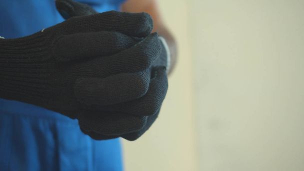 Από κοντά, ο άνθρωπος φοράει προστατευτικά γάντια. - Φωτογραφία, εικόνα