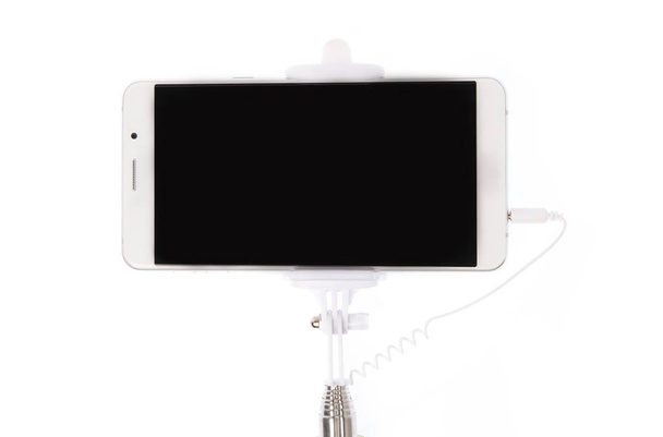 palo selfie con teléfono móvil aislado sobre un fondo blanco
 - Foto, Imagen