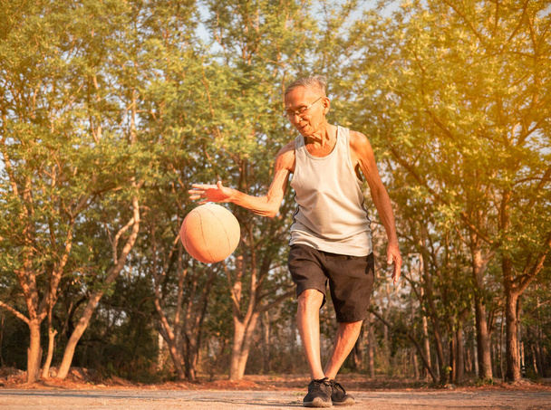 Asiatische ältere Männer spielen an Sommertagen Basketball auf Spielplatz - Foto, Bild