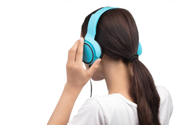 Jeune femme Écouter de la musique dans un casque bleu isolé sur blanc
  - Photo, image