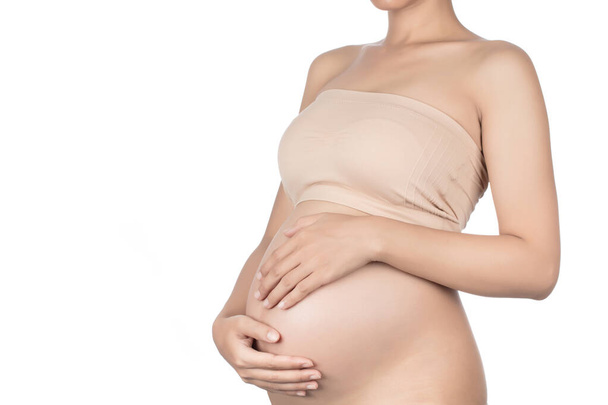 Молодая беременная женщина обнимает голый живот руками. iso
 - Фото, изображение