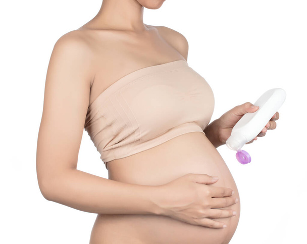 incinta signora sfregamento crema sul suo ventre isolato su bianco backg
 - Foto, immagini