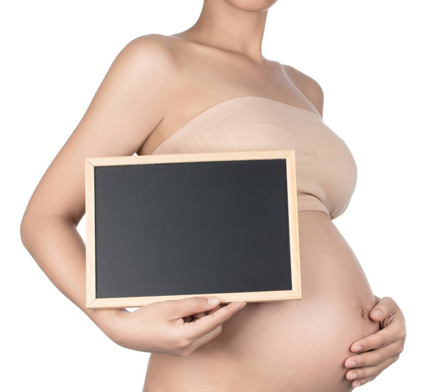 Young pregnant woman holding a blackboard isolated on white back - Fotoğraf, Görsel