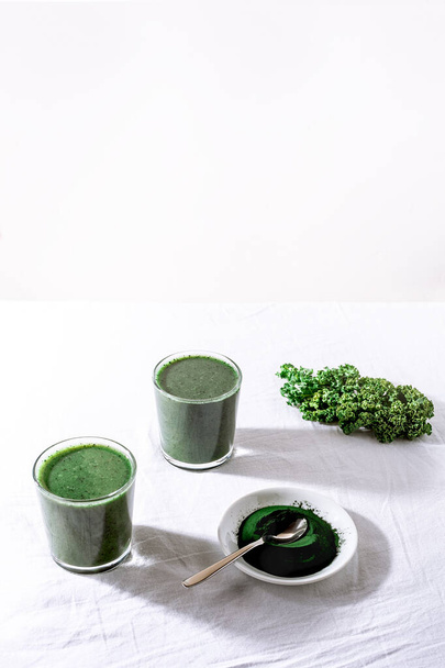 Color green spinach kale apple yogurt smoothie with spirulina on white background with shadow - Foto, imagen