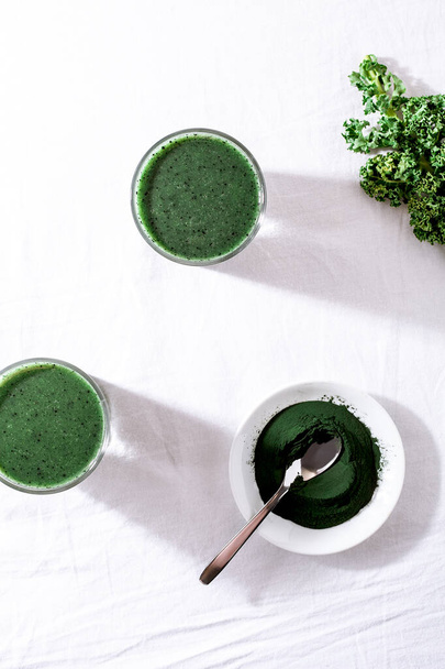Color green spinach kale apple yogurt smoothie with spirulina on white background with shadow - Foto, Imagem