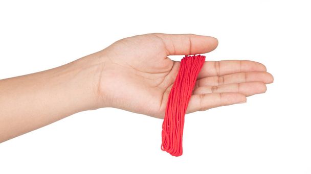 hand houden Close up rode garen draad geïsoleerd op witte backgrou - Foto, afbeelding