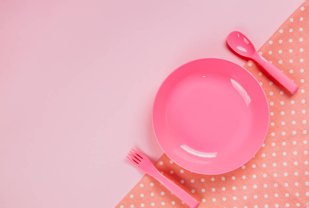 Πιάτο πλαστικό ροζ χρώμα με πλαστικό κουτάλι, πιρούνι και ροζ πόλκα - Φωτογραφία, εικόνα