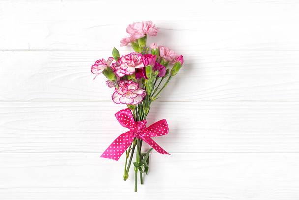 csokor különböző rózsaszín szegfű virágok fehér fa háttér Top view Flat lay Üdülési kártya 8 Március, Boldog Valentin-napot, Anyák napi koncepció - Fotó, kép