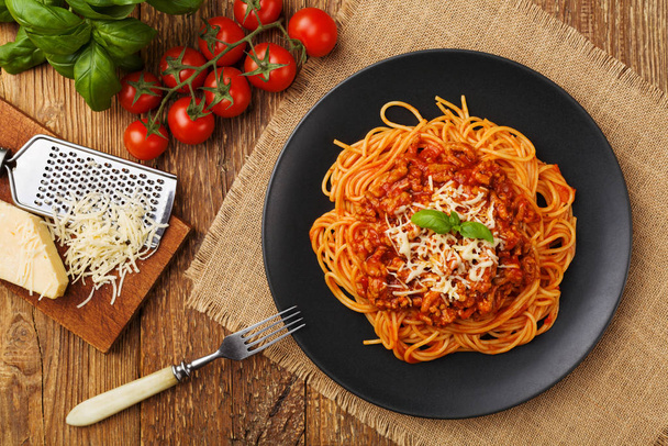 Delicious spaghetti served on a black plate - Foto, afbeelding