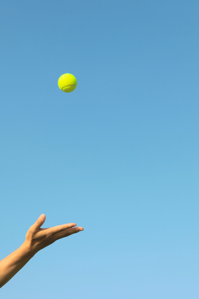 Tennis jeté à la main dans le ciel bleu fond
 - Photo, image