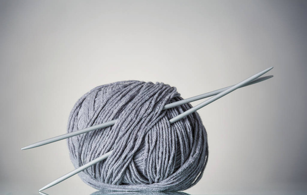 Coil of gray yarn and needles for needlework, on gray - Foto, Imagem
