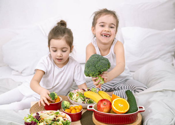 Здорова їжа, діти їдять фрукти та овочі
. - Фото, зображення