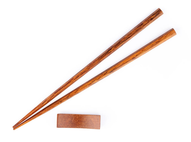 paire de baguettes en bois avec support en bois isolé sur un bac blanc
 - Photo, image