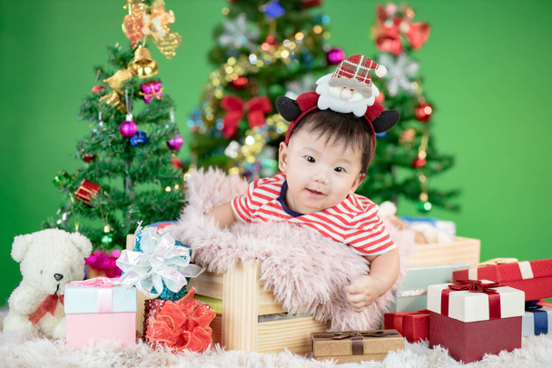 Симпатичный малыш в деревянной коробке с рождественским подарком на Рождество
 - Фото, изображение
