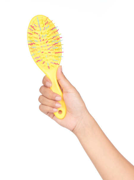 hand holding yellow of comb isolated on a white background - Фото, изображение
