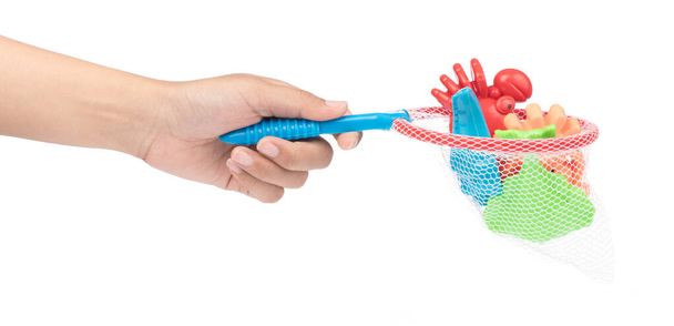 χέρι εκμετάλλευση παιχνιδιών πλαστικά καλούπια άμμου της θάλασσας πλάσμα απομονωμένο στις  - Φωτογραφία, εικόνα