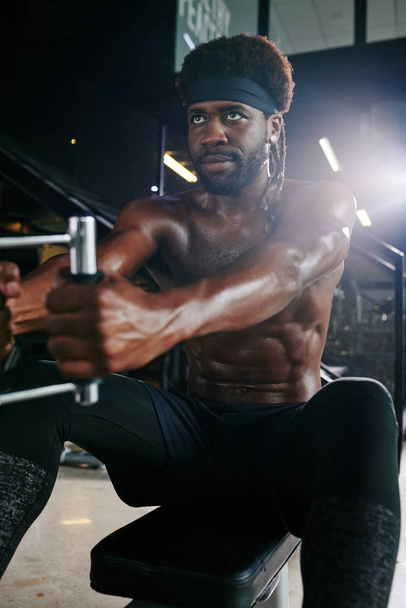Κάθετη πορτρέτο του αθλητικού Αφροαμερικανού κάνει την ενίσχυση της άσκησης στο γυμναστήριο με τη χρήση του γυμναστηρίου - Φωτογραφία, εικόνα