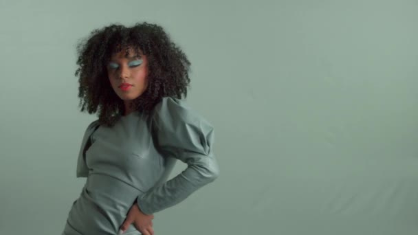 mixed race woman with big curly hair in leather fashion dress in studio - Video