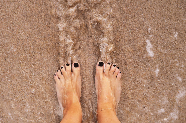 Female legs on sand texture. - Photo, Image