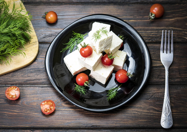 Cheese and tomatoes on a wooden background - Foto, imagen