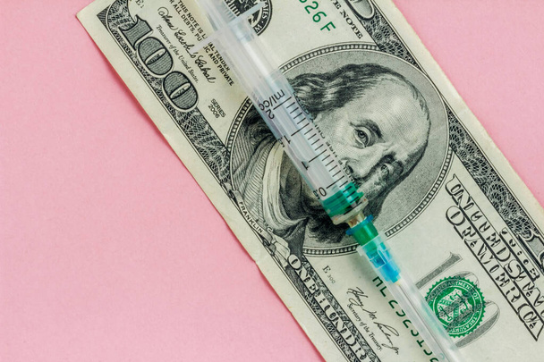 American dollar and empty syringe on pink background, vaccination concept, high cost of medical servicesy, flat lay - Фото, зображення
