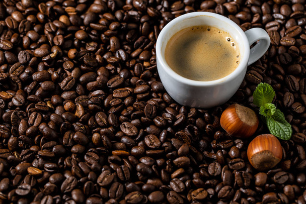 Чашка кави на кавових майданчиках з фундуком
 - Фото, зображення
