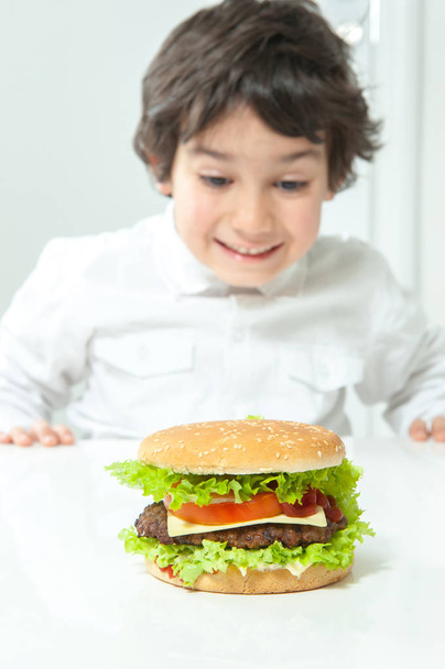 Child eating burger close up - Φωτογραφία, εικόνα