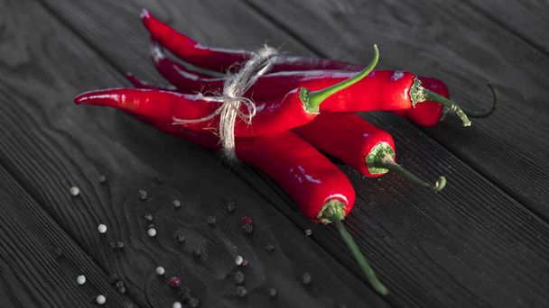 Rode chili peper op zwarte houten achtergrond - Foto, afbeelding