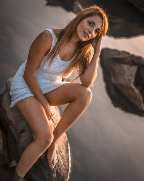sunset portrait of beautiful young woman at sea shore - Foto, afbeelding