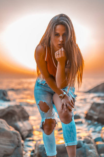  portrait of beautiful young woman at sea shore on sunset  - Фото, изображение