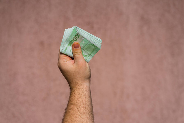 Kädessä pitäminen ja eurorahan näyttäminen tai rahan antaminen. Maailmanraha
 - Valokuva, kuva