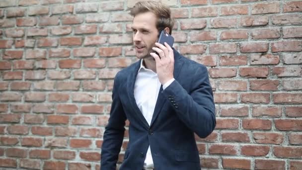 feliz joven inteligente hombre casual contestando su teléfono, hablando y luego guardando su teléfono, en el bolsillo interior de su abrigo
 - Imágenes, Vídeo