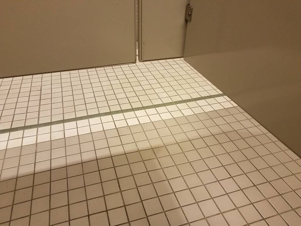 grey bathroom stall door with white tiles - Foto, Bild