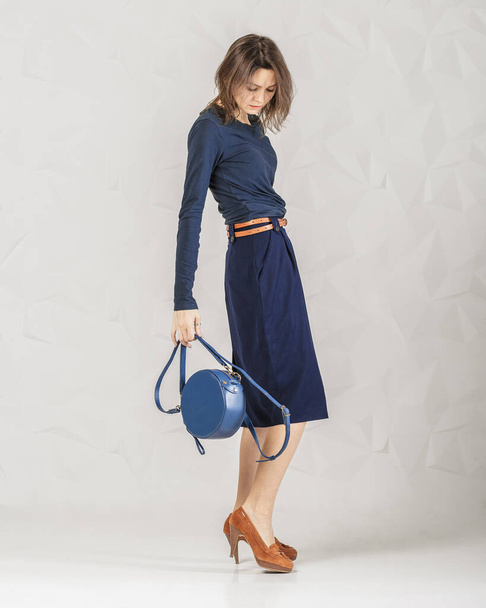 Stylowa modna kobieta z niebieską okrągłą torbą - Zdjęcie, obraz