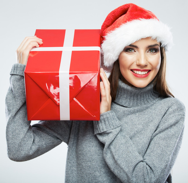Portrait of woman in santa hat holding gift box - Foto, Bild