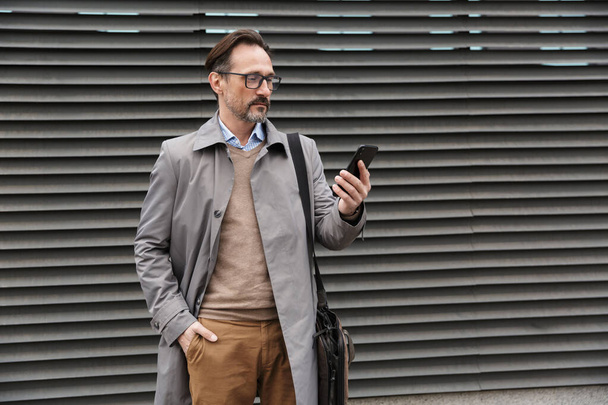 Image of handsome businessman using cellphone while standing - Fotoğraf, Görsel