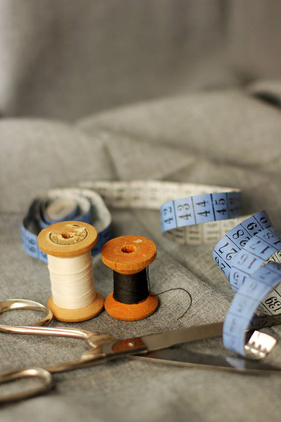 Sewing. Spools of thread on the fabric. Threads. Meter and scissors - Φωτογραφία, εικόνα